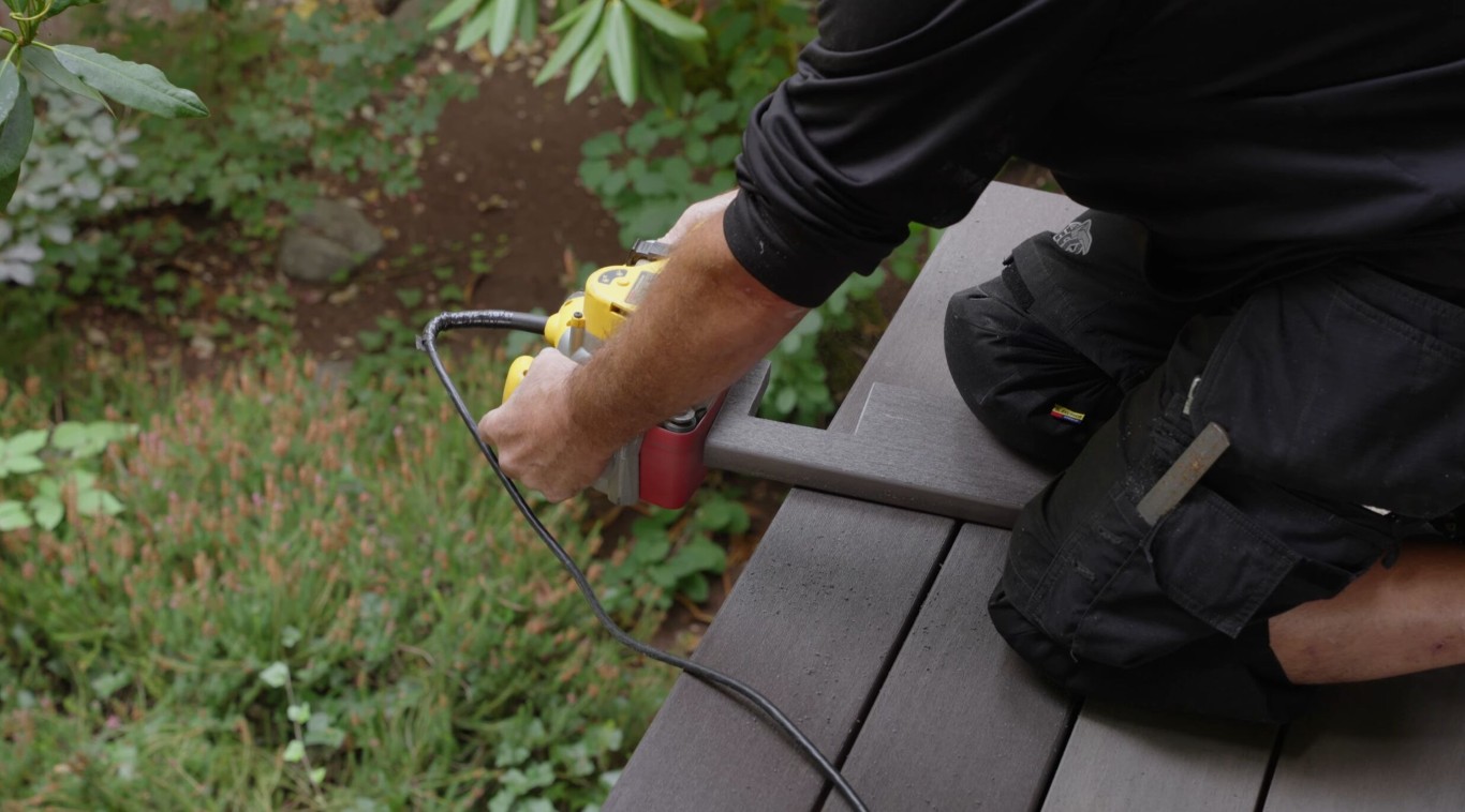 Professional deck builder using power tools to install composite decking in Turlock, CA